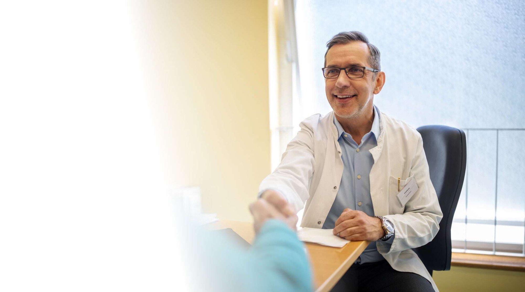 Arzt, der einem Patienten die Hand gibt